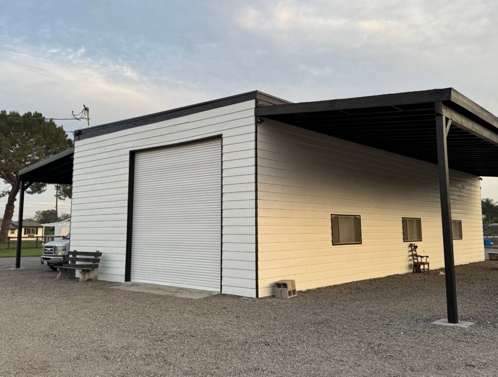 freshly painted white commercial building with black trim and roll up garage door